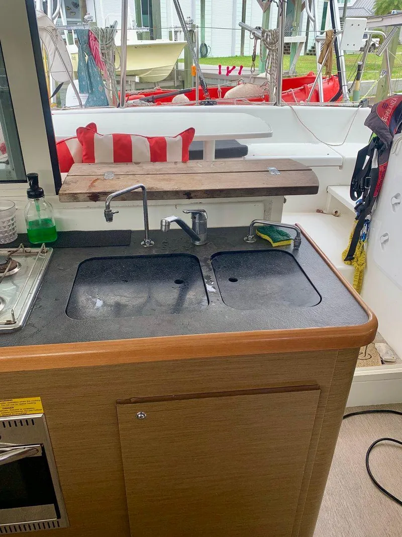 Slide: The Image of Kitchen area on a 2019 Lagoon 380 S2 4/2 catamaran with dual sinks and outdoor view. - 18