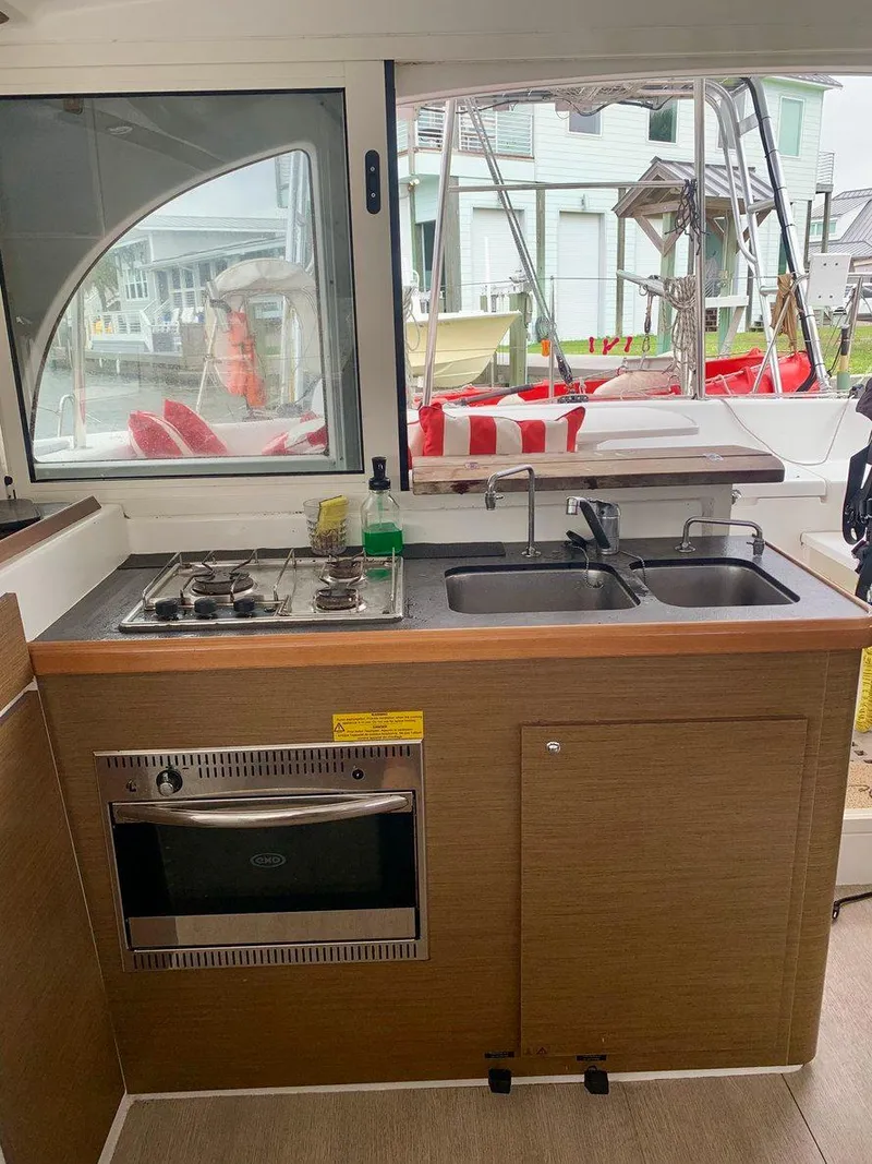 Slide: The Image of 2019 Lagoon 380 S2 4/2 yacht kitchen with stove, oven, and dual sinks. - 19