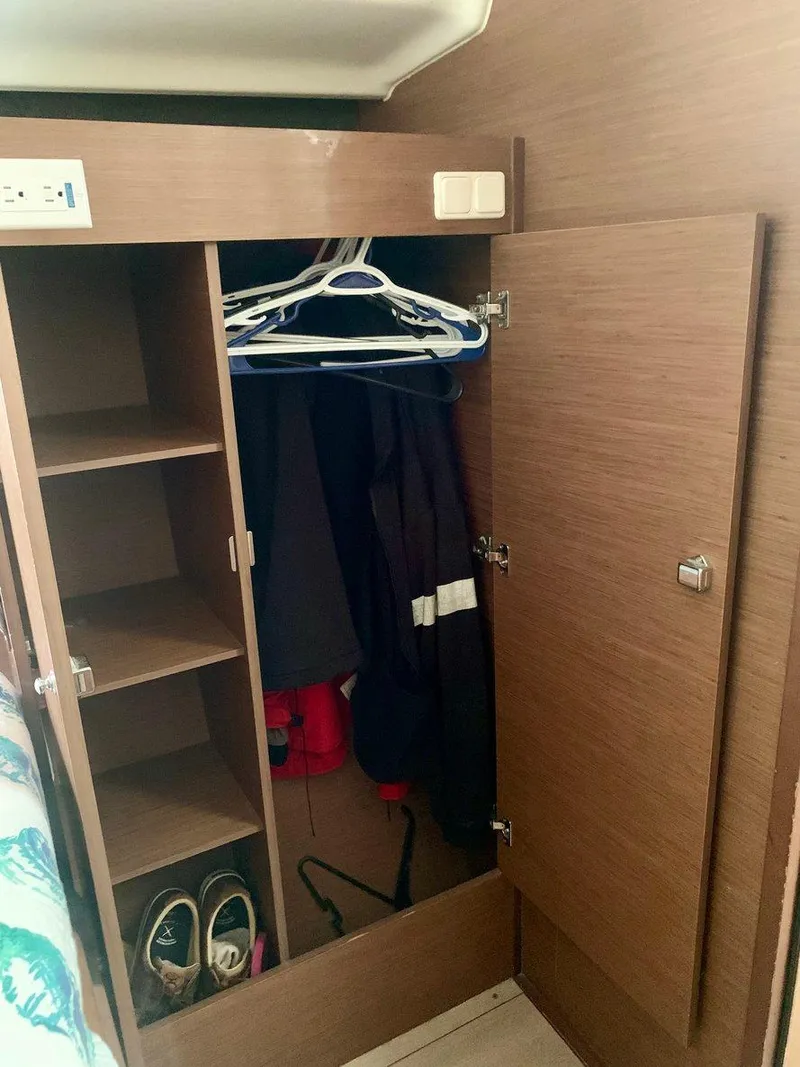 Slide: The Image of Wooden closet interior on 2019 Lagoon 380 S2 4/2 yacht, with shelves and hanging space. - 31