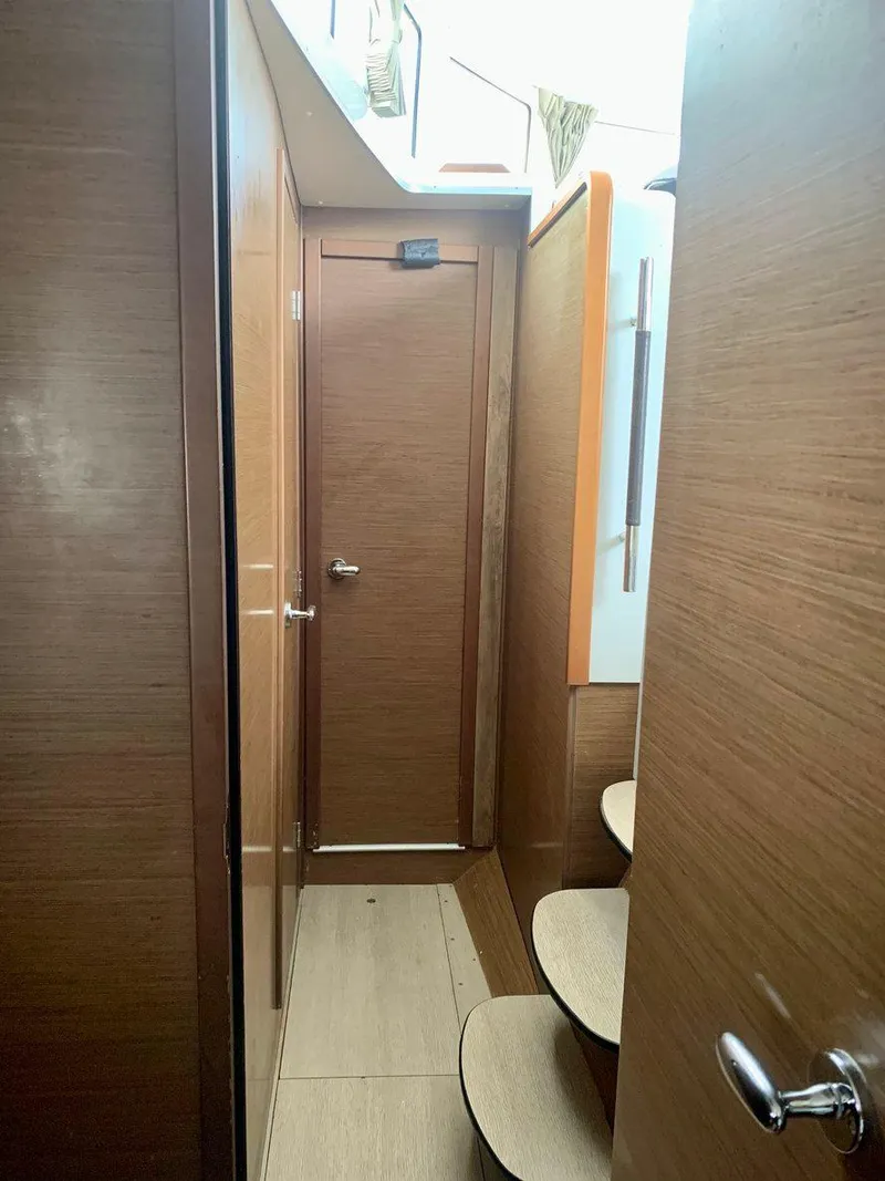 Slide: The Image of Interior hallway of 2019 Lagoon 380 S2 4/2 catamaran with wooden finish and steps. - 32