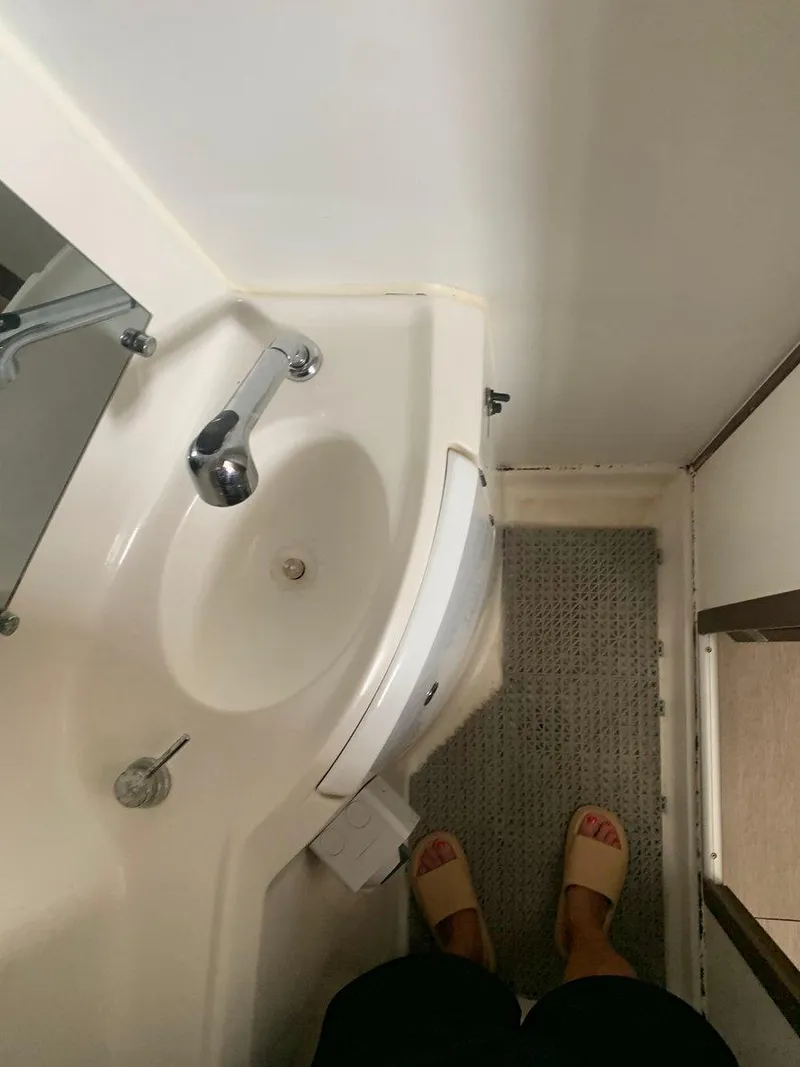 Slide: The Image of Compact bathroom in 2019 Lagoon 380 S2 4/2 catamaran with sink and carpeted floor. - 33