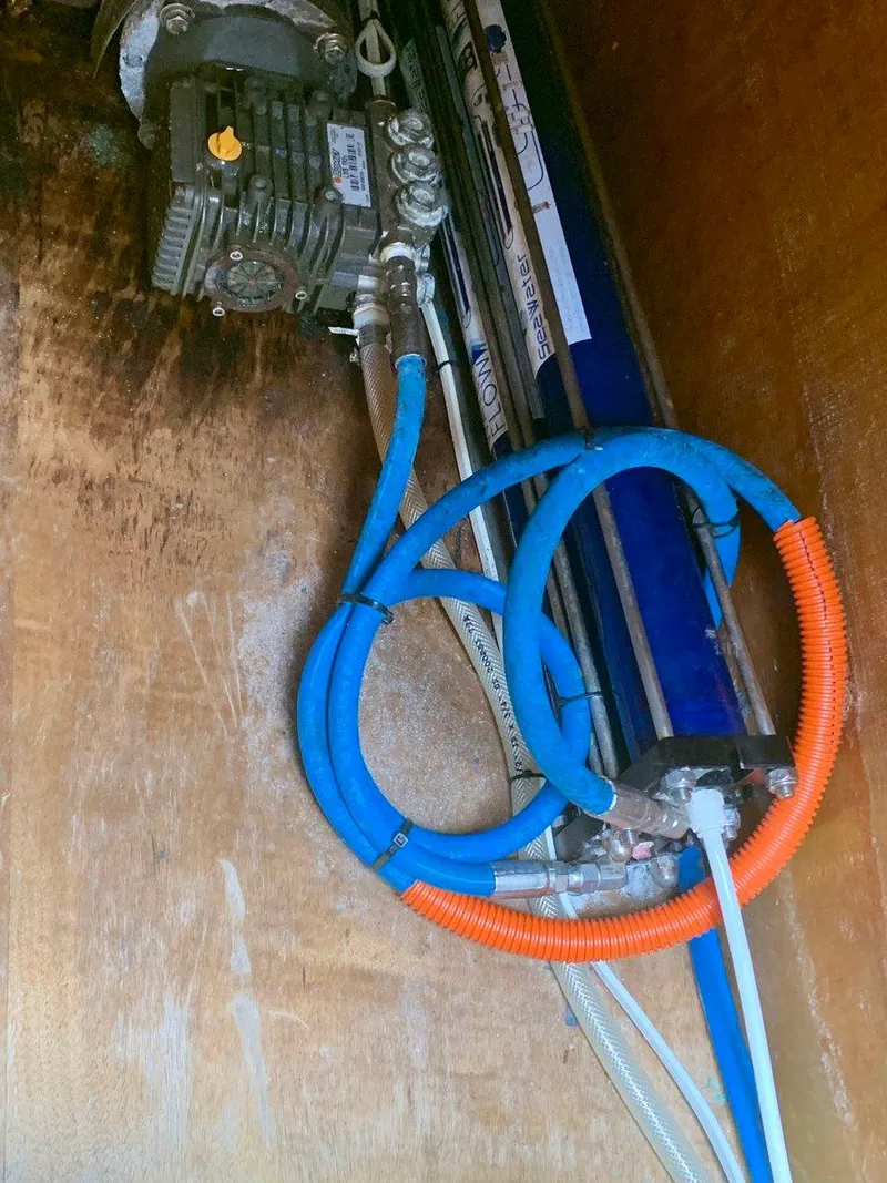 Slide: The Image of Engine compartment of a 2019 Lagoon 380 S2 4/2 with visible hoses and machinery. - 44