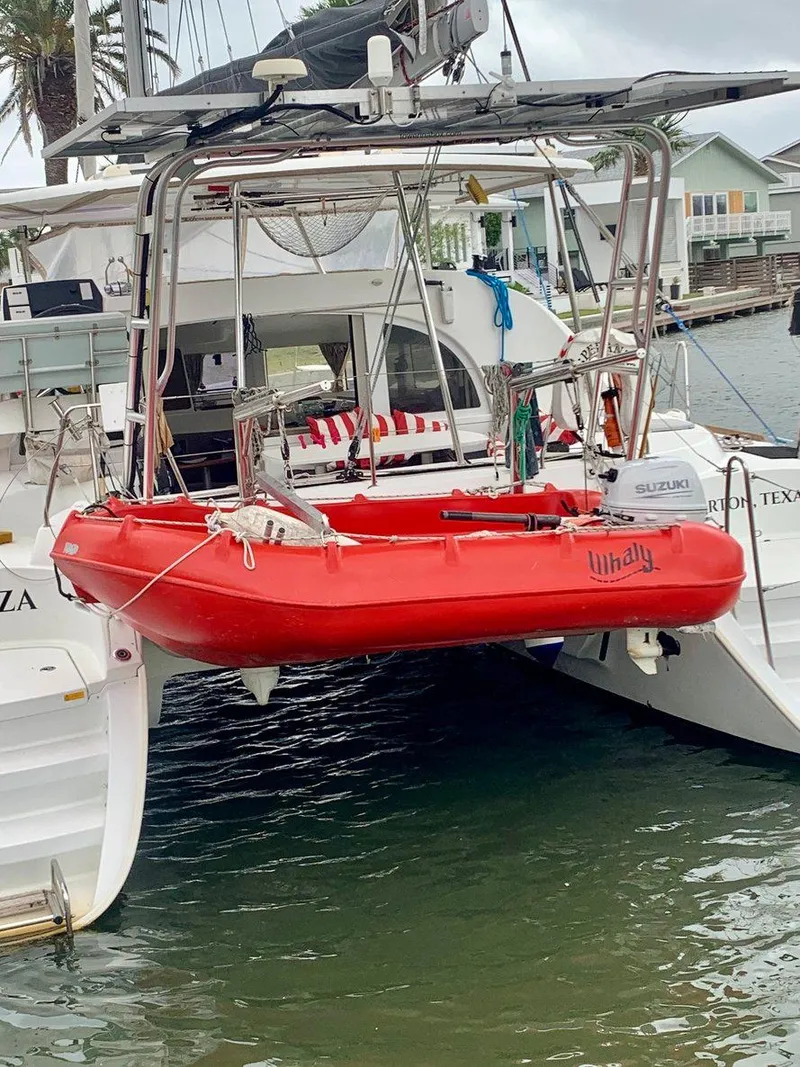Slide: The Image of Lagoon 380 S2 4/2 catamaran with red dinghy, docked in a marina, 2019 model. - 46