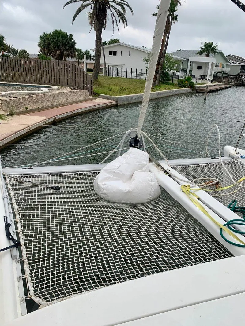 Slide: The Image of 2019 Lagoon 380 S2 4/2 catamaran docked by a canal with netting and ropes. - 9