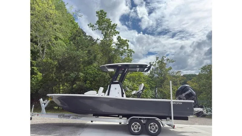 Slide: The Image of 2025 Sea Fox 251 Bay Fox boat on trailer, surrounded by lush greenery and cloudy sky. - 12