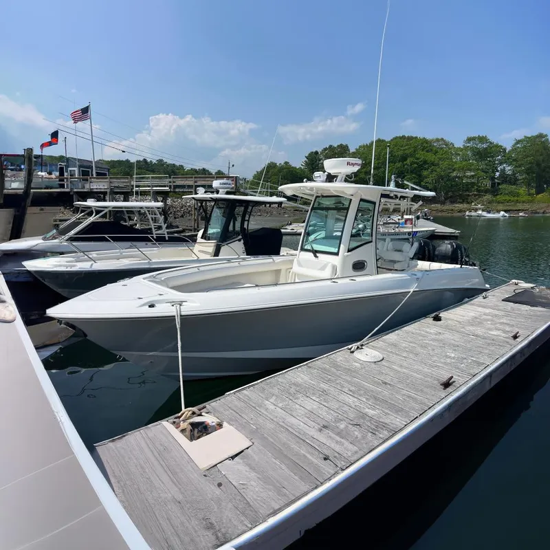 The Image of 2012 Boston Whaler 280 Outrage docked at a marina under clear skies. - 0
