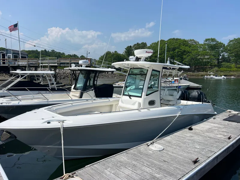 Slide: The Image of 2012 Boston Whaler 280 Outrage docked at a marina under clear skies. - 1