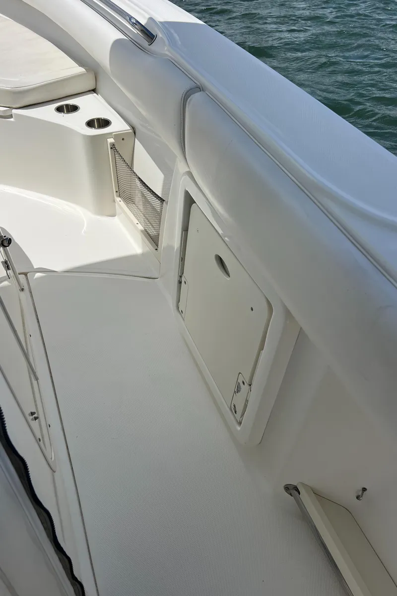 Slide: The Image of 2012 Boston Whaler 280 Outrage boat interior with storage compartment and cup holders. - 5