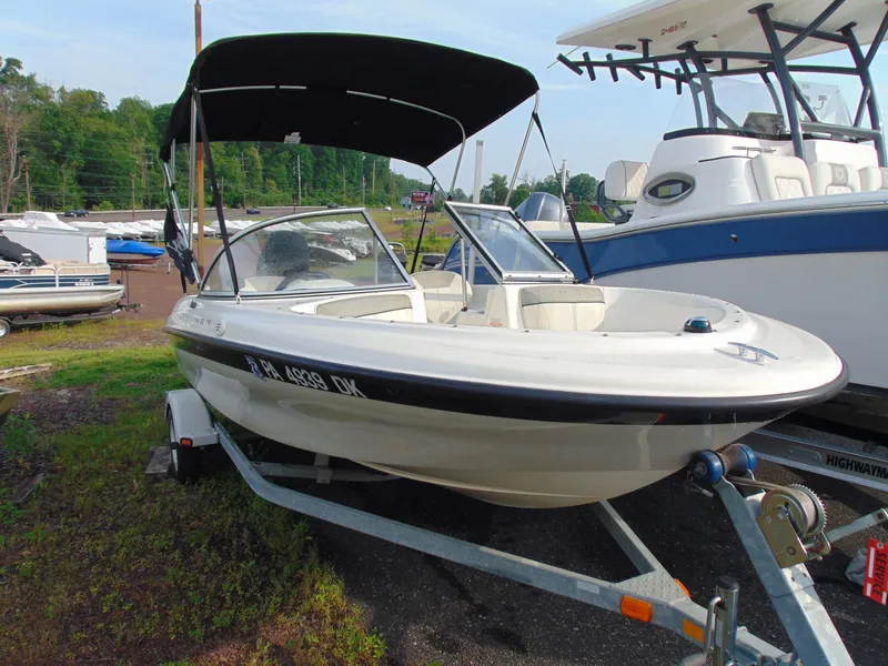 Slide: The Image of 2013 Bayliner 160BR boat with canopy on trailer, parked outdoors. - 4