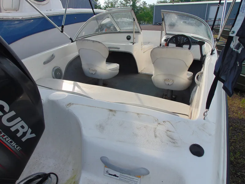 Slide: The Image of 2013 Bayliner 160BR boat interior with seating and steering wheel, featuring a Mercury outboard motor. - 6