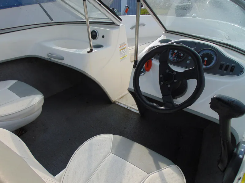 Slide: The Image of 2013 Bayliner 160BR boat interior with steering wheel and seating. - 9