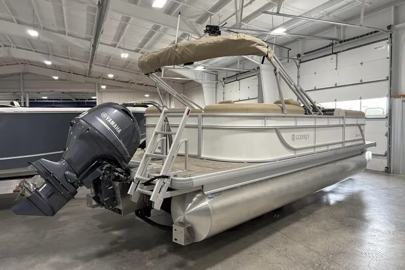 Slide: The Image of 2025 Godfrey Xperience 2286 SBX Sport Tube pontoon boat with Yamaha outboard motor in a garage. - 2