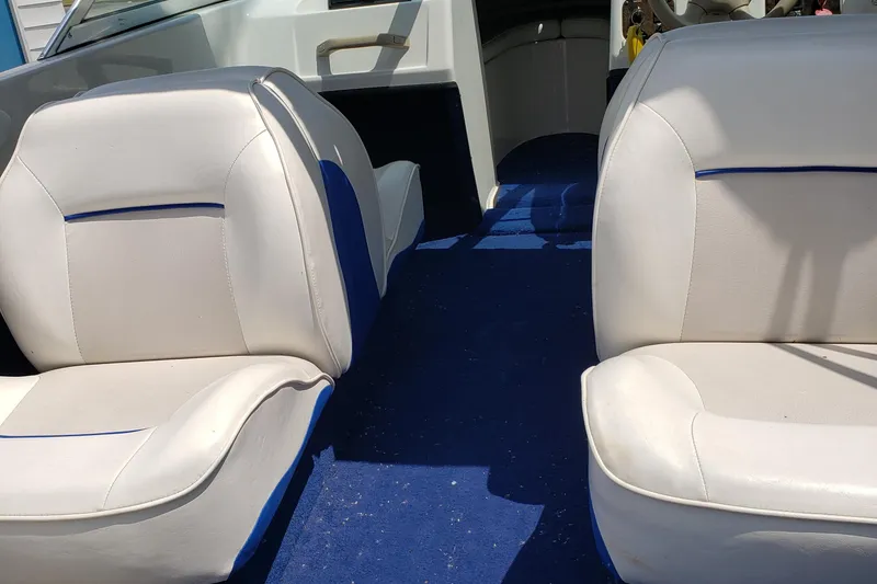 Slide: The Image of Interior of a 1998 Sunbird 150 boat with white and blue seating. - 2
