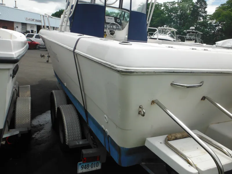 Slide: The Image of 1997 Pro-Line 231 WA boat on trailer, white and blue, parked outdoors. - 11