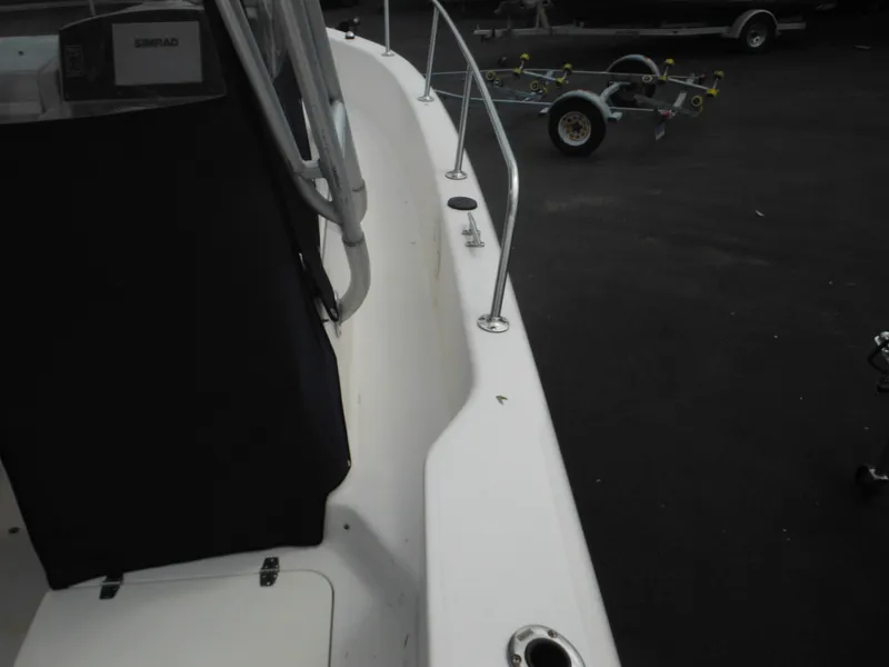 Slide: The Image of 1997 Pro-Line 231 WA boat deck with railing and trailer in background. - 13