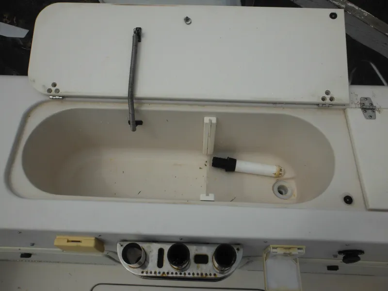 Slide: The Image of 1997 Pro-Line 231 WA boat compartment with open lid and control panel. - 15
