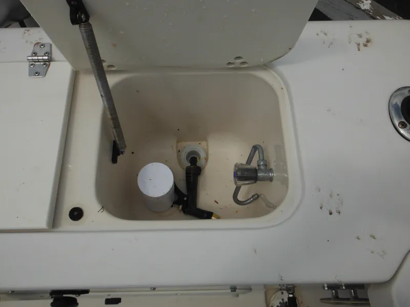 Slide: The Image of 1997 Pro-Line 231 WA boat storage compartment with latch and spring mechanism. - 16