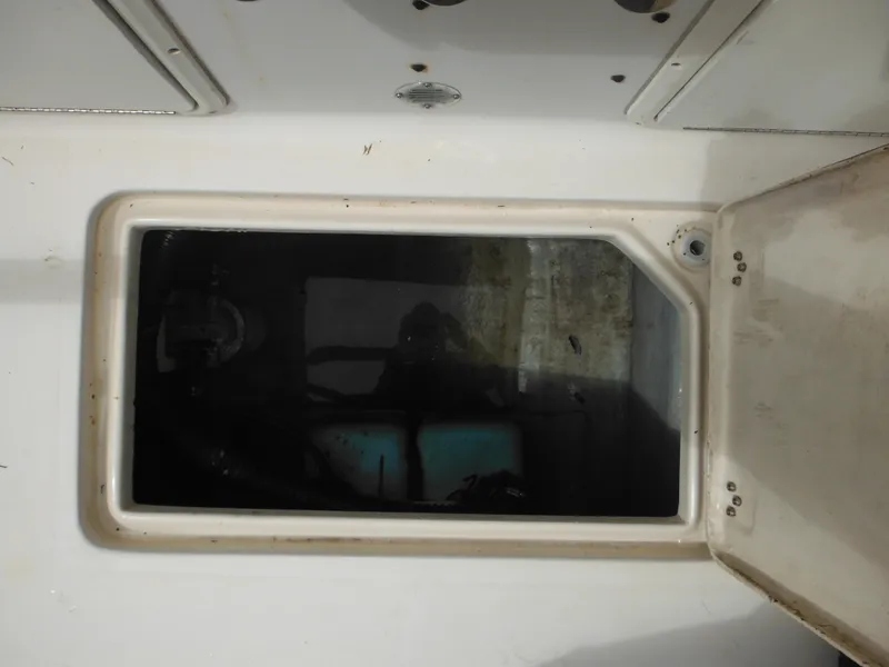 Slide: The Image of 1997 Pro-Line 231 WA boat compartment with open hatch, showing interior storage space. - 17