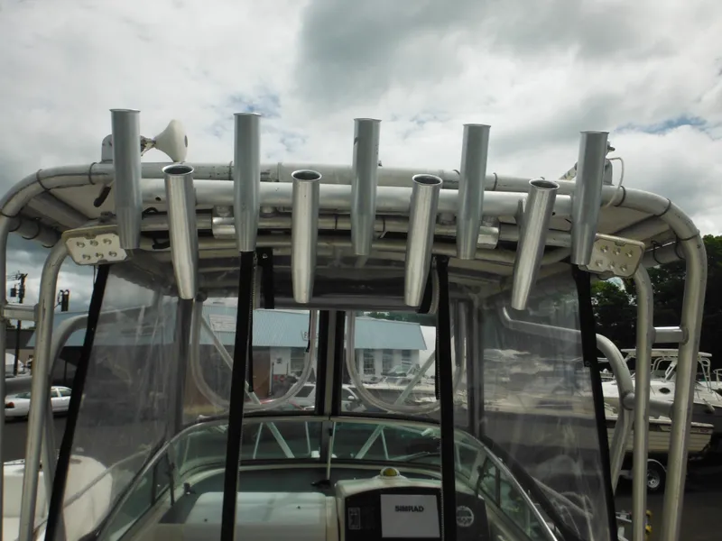 Slide: The Image of 1997 Pro-Line 231 WA boat with rod holders and canopy under cloudy sky. - 20