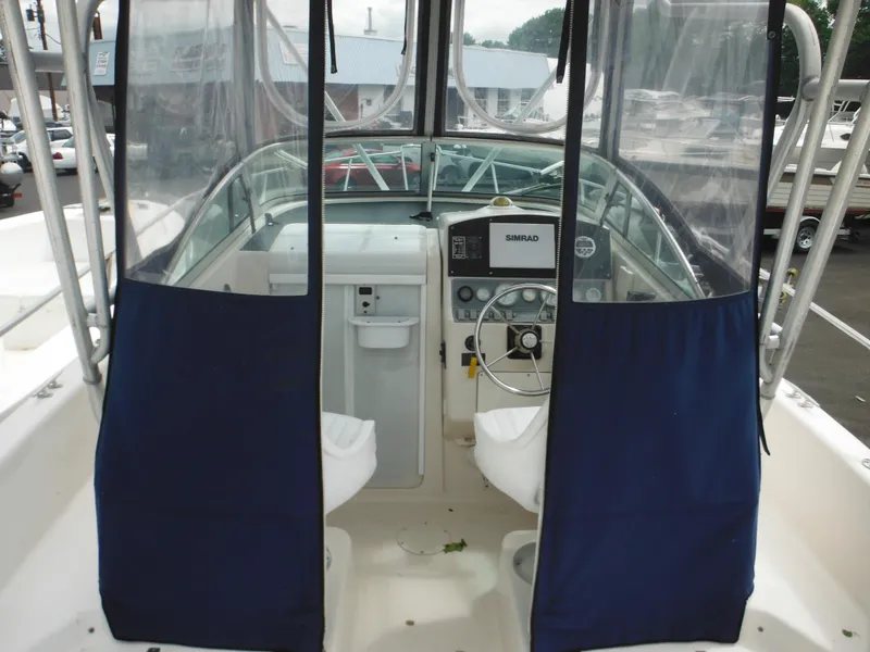 Slide: The Image of 1997 Pro-Line 231 WA boat interior with steering wheel and blue curtains. - 21