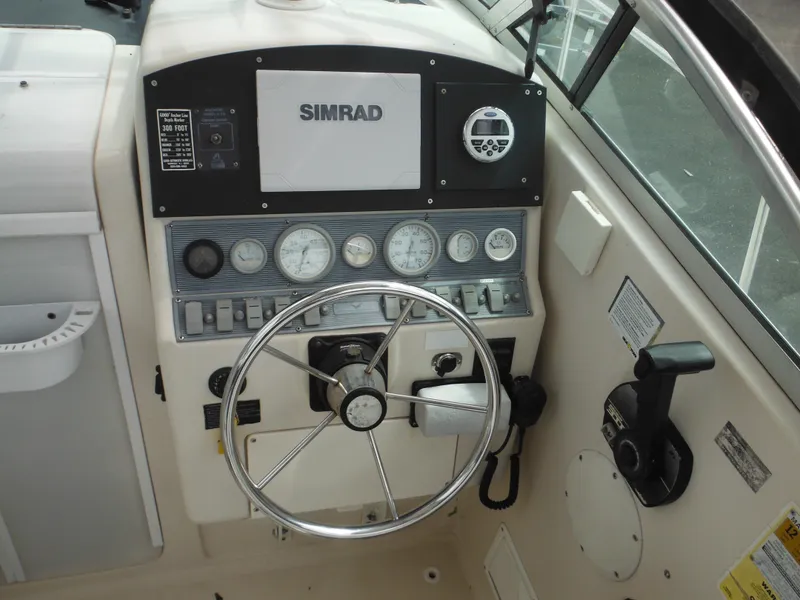 Slide: The Image of 1997 Pro-Line 231 WA boat dashboard with steering wheel and Simrad navigation system. - 22