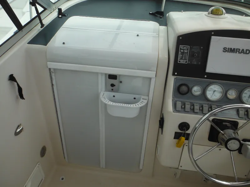 Slide: The Image of 1997 Pro-Line 231 WA boat dashboard with Simrad controls and steering wheel. - 23