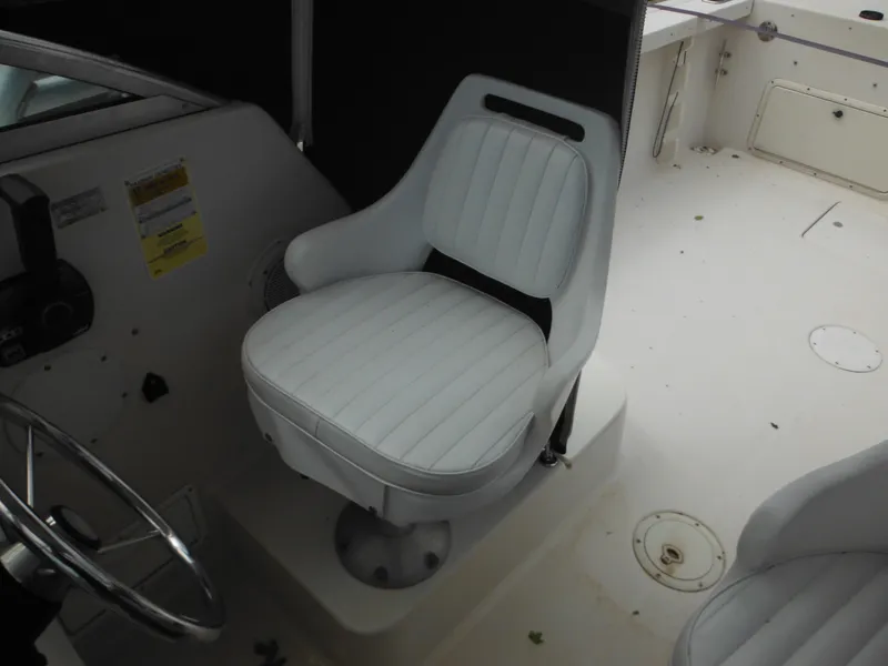 Slide: The Image of 1997 Pro-Line 231 WA boat interior with white captain's chair and steering wheel. - 24
