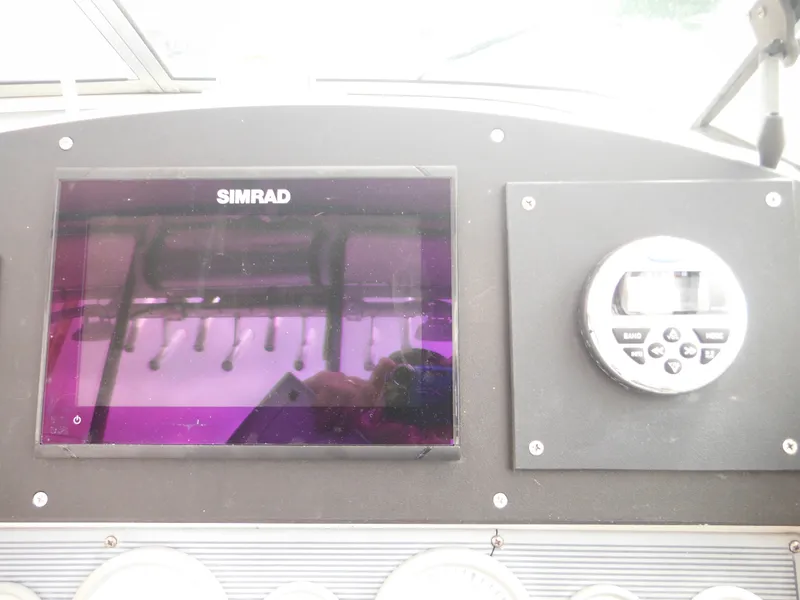 Slide: The Image of 1997 Pro-Line 231 WA boat dashboard with Simrad display and control panel. - 26