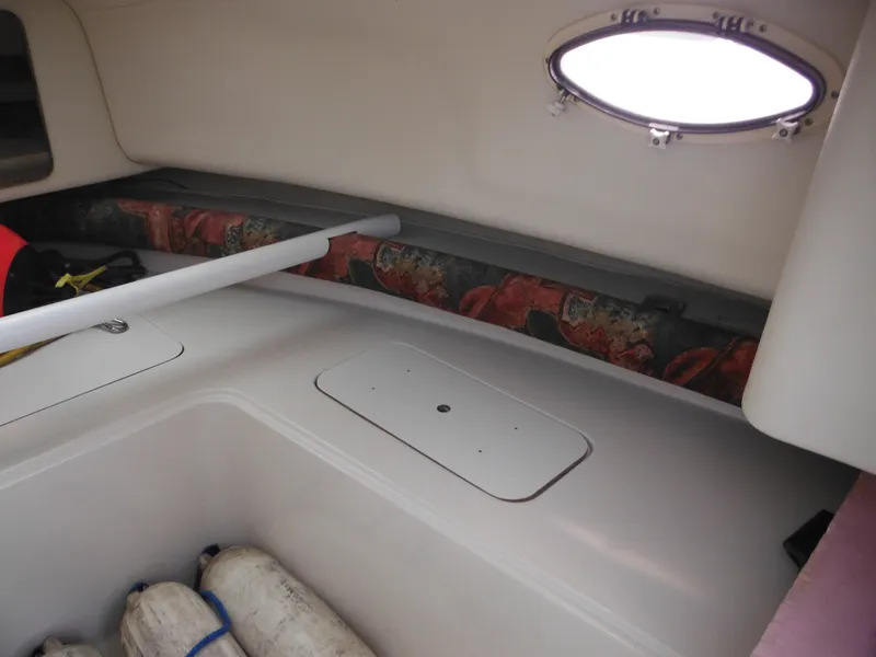Slide: The Image of Interior of 1997 Pro-Line 231 WA boat, featuring storage and porthole. - 32