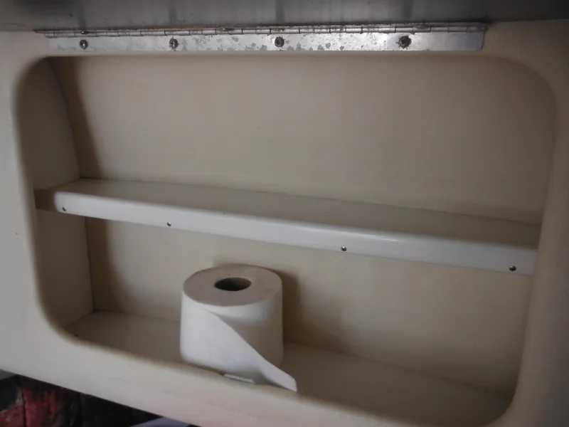 Slide: The Image of 1997 Pro-Line 231 WA boat interior storage with toilet paper roll. - 35