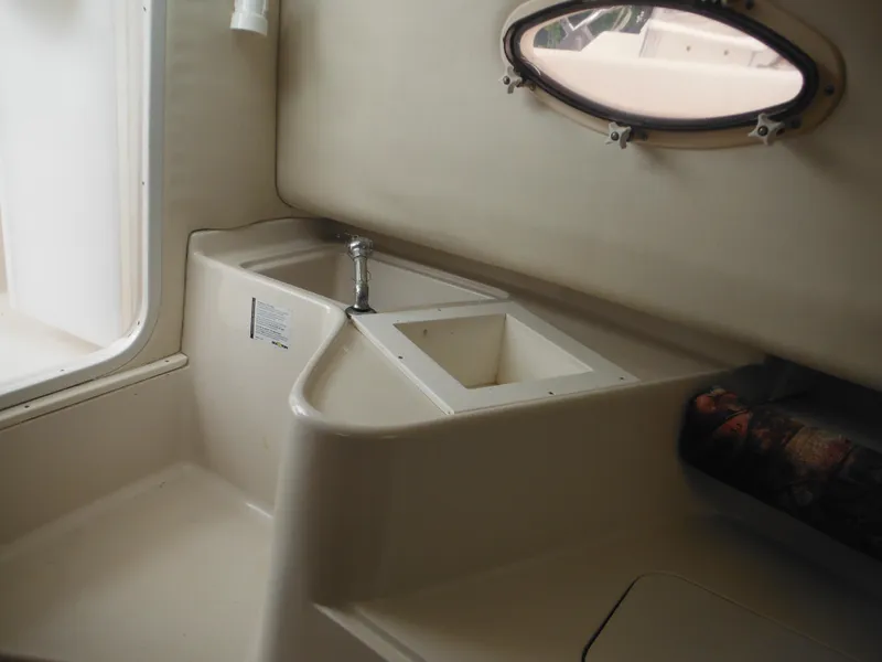 Slide: The Image of Interior view of 1997 Pro-Line 231 WA boat, featuring a compact sink and window. - 39