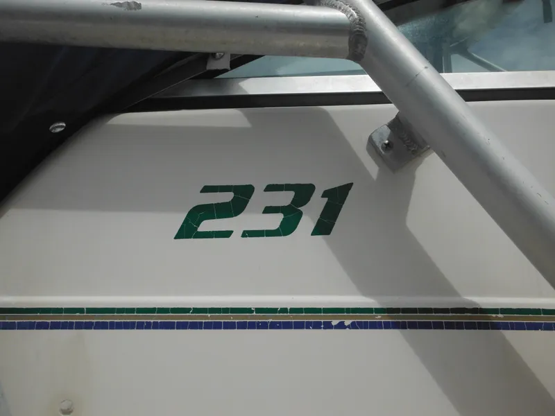 Slide: The Image of 1997 Pro-Line 231 WA boat with green "231" decal on white hull. - 6