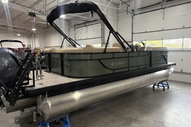 Slide: The Image of 2025 Godfrey Xperience 2286 SBX pontoon boat in a showroom, featuring iMPACT Center Tube Package. - 26