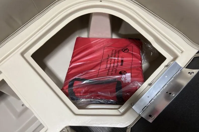 Slide: The Image of Storage compartment with a red life jacket in a 2025 Godfrey Xperience 2286 SBX boat. - 27