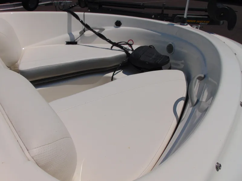 Slide: The Image of 2010 Bayliner 160 Bowrider interior with white seating and storage compartments. - 11