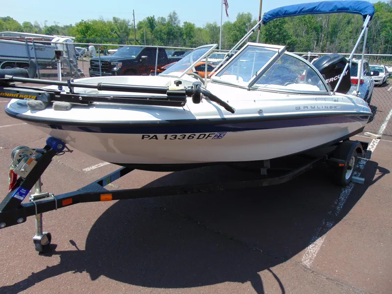 Slide: The Image of 2010 Bayliner 160 Bowrider boat on trailer, parked outdoors. - 3