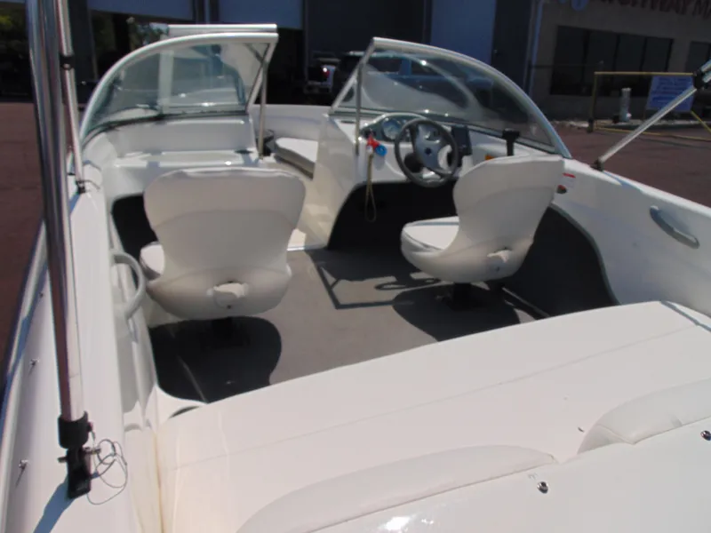 Slide: The Image of 2010 Bayliner 160 Bowrider interior with white seating and steering wheel. - 7