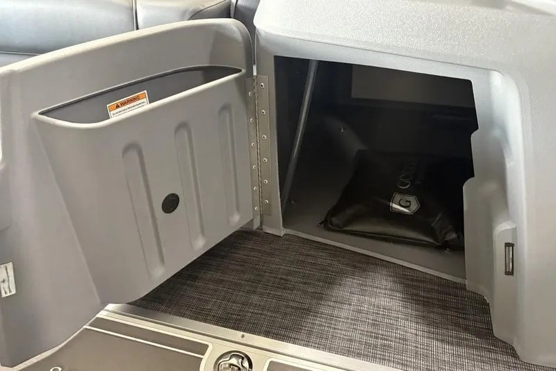 Slide: The Image of 2025 Godfrey Sweetwater 2286 SFL storage compartment with open door and interior view. - 14
