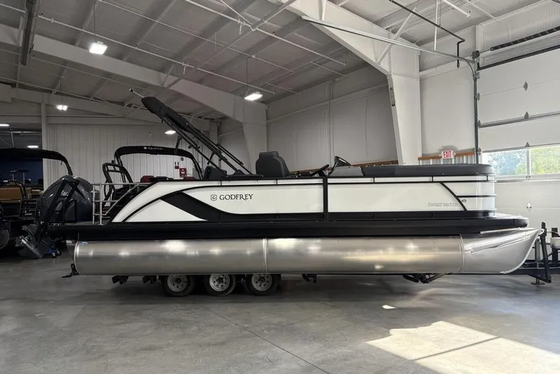 The Image of 2025 Godfrey Sweetwater 2286 SFL pontoon boat in a showroom, side view. - 2