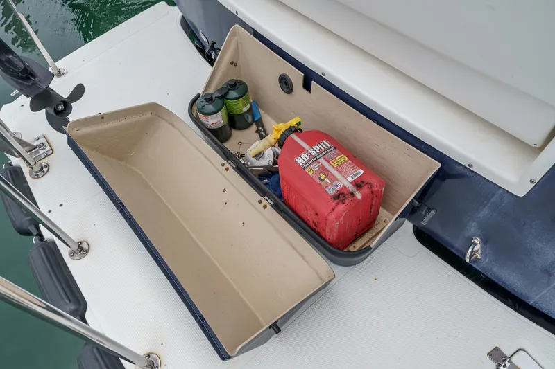 Slide: The Image of Open storage compartment on 2014 Cutwater C-30 SC LE boat with fuel can and supplies. - 10