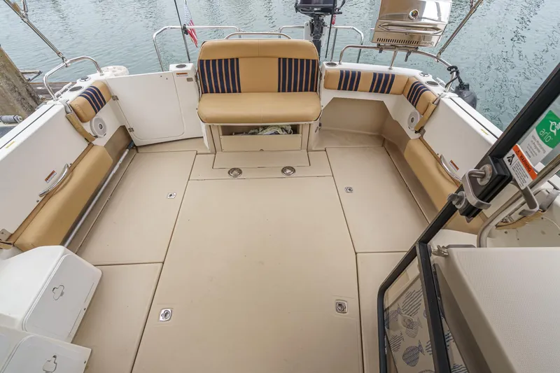 Slide: The Image of 2014 Cutwater C-30 SC LE boat deck with beige seating and striped cushions. - 12