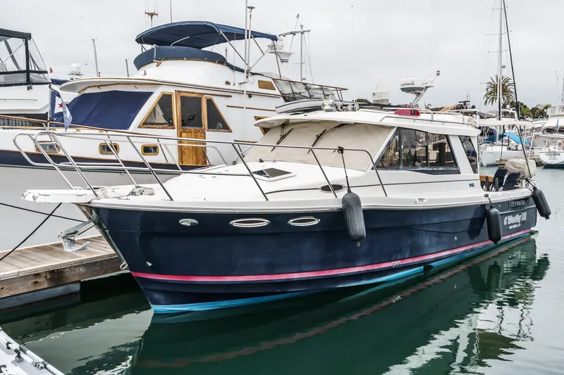 Slide: The Image of 2014 Cutwater C-30 SC LE boat docked at marina, featuring sleek design and blue hull. - 2