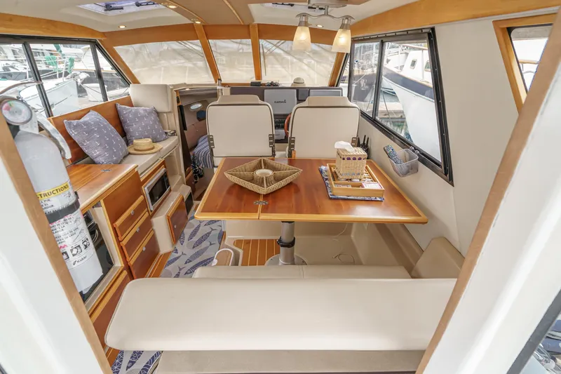 Slide: The Image of 2014 Cutwater C-30 SC LE interior with dining area, wooden table, and cozy seating. - 27