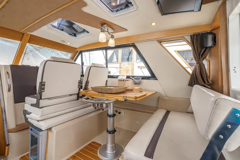 Slide: The Image of Interior of 2014 Cutwater C-30 SC LE boat, featuring seating and dining area with natural light. - 32