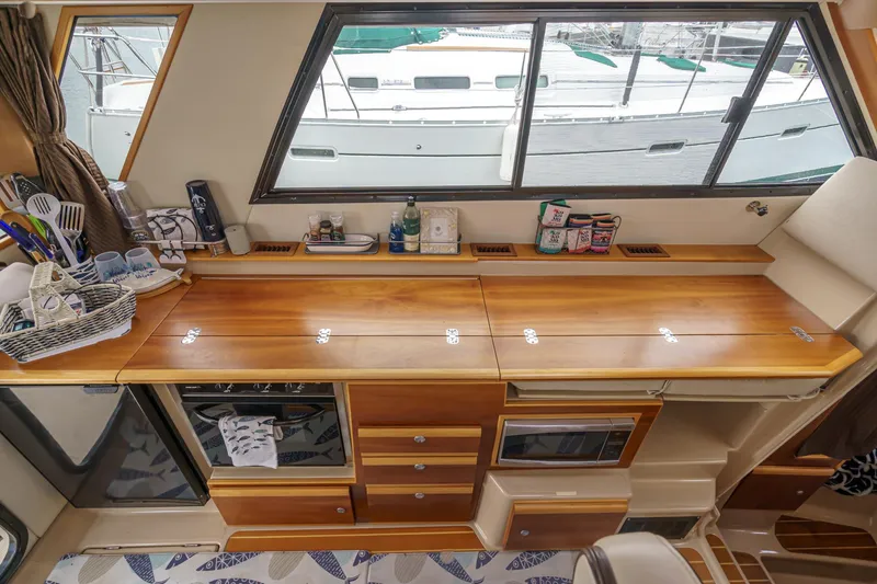 Slide: The Image of 2014 Cutwater C-30 SC LE interior with wooden cabinetry and kitchen appliances. - 39