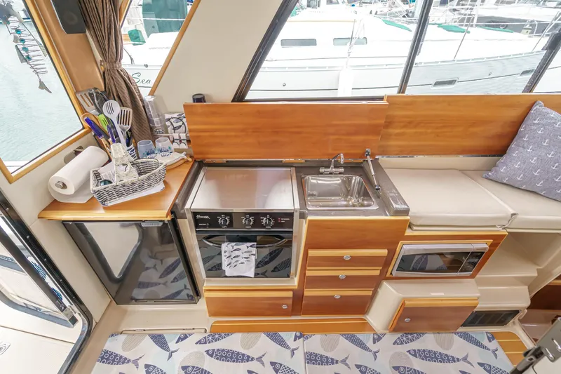 Slide: The Image of Compact kitchen in 2014 Cutwater C-30 SC LE boat with stove, sink, and storage. - 40