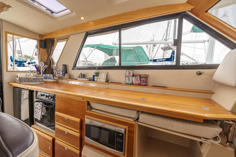 Slide: The Image of Interior of 2014 Cutwater C-30 SC LE boat with kitchen amenities and wooden cabinetry. - 44