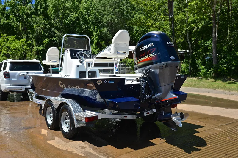 Slide: The Image of 2019 G3 Bay 20 DLX boat with Yamaha engine on trailer, parked near trees. - 12