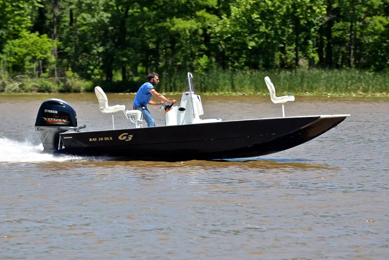 Slide: The Image of 2019 G3 Bay 20 DLX boat cruising on a lake with lush green trees in the background. - 3