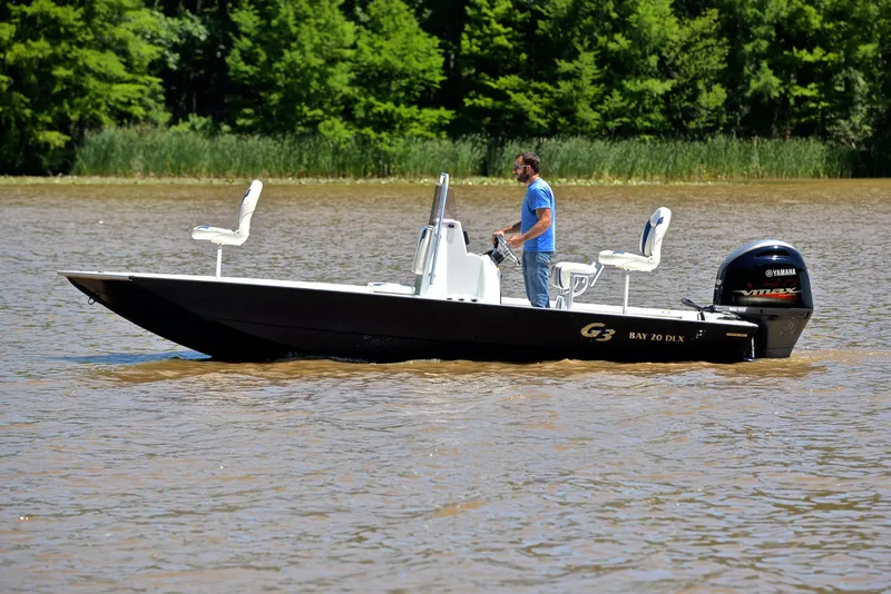 Slide: The Image of 2019 G3 Bay 20 DLX boat on a lake with a person steering. - 9